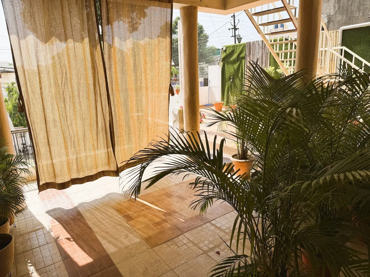 Morning light through linen curtains on the pillared verandah of the Grandeur Villa