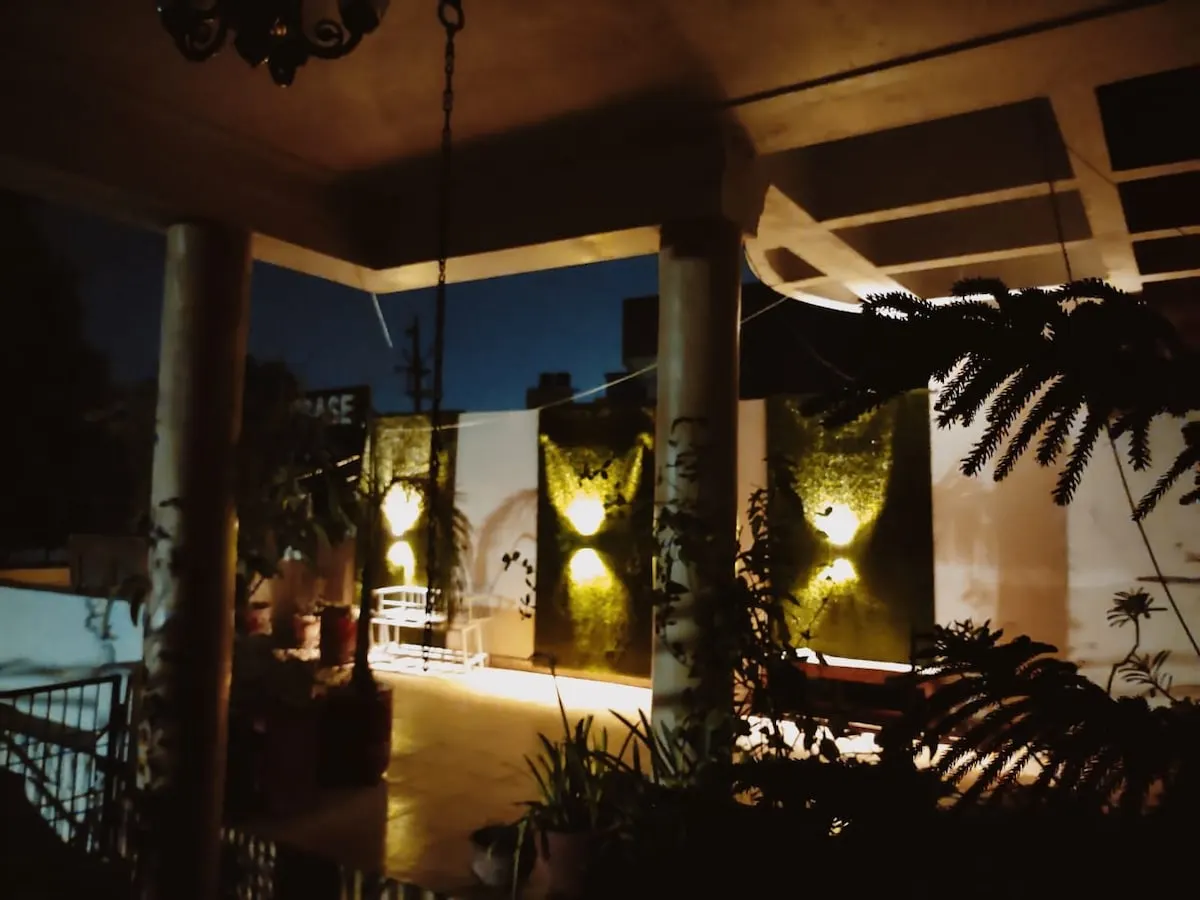 The porch of the Grandeur Villa at night, garden walls lit in warm light